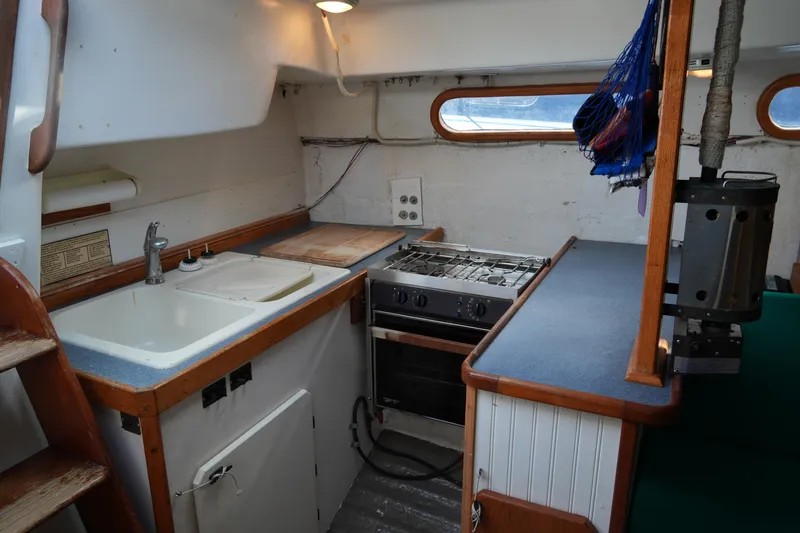 Slide: The Image of 1974 Morgan 33 Out Island yacht kitchen with sink, stove, and counter space. - 23
