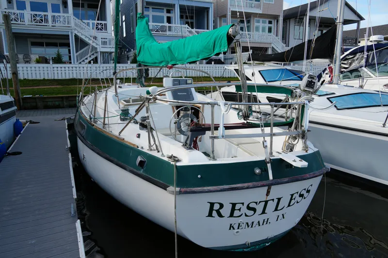 Slide: The Image of 1974 Morgan 33 Out Island sailboat docked, named "Restless," with green accents, in Kemah, TX. - 3