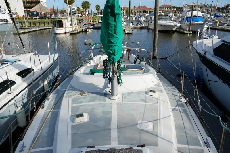Slide: The Image of 1974 Morgan 33 Out Island sailboat docked in a marina, surrounded by other boats. - 6
