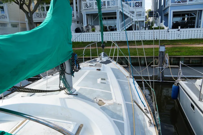 Slide: The Image of 1974 Morgan 33 Out Island sailboat docked near waterfront homes. - 7