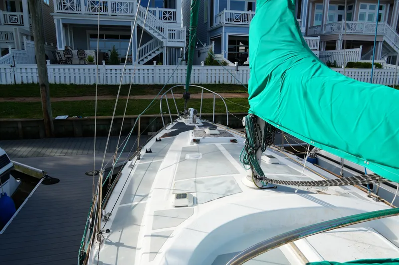 Slide: The Image of 1974 Morgan 33 Out Island sailboat docked near waterfront homes. - 8