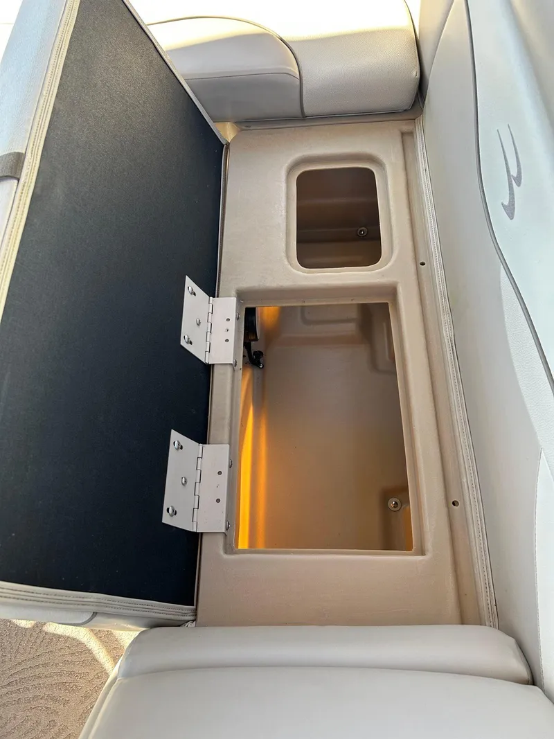 Slide: The Image of 2012 Bennington 20SLi boat storage compartment with open lid, showcasing interior space. - 15