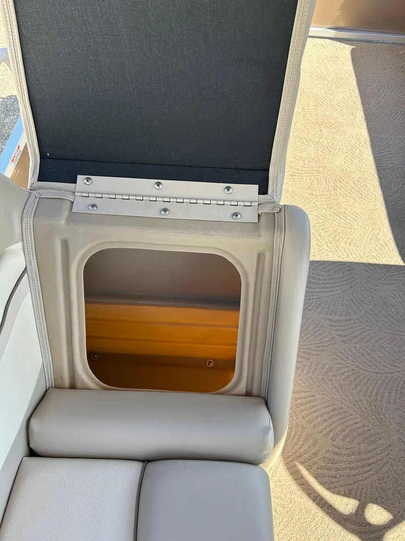 Slide: The Image of 2012 Bennington 20SLi boat seat storage compartment with open lid, revealing interior space. - 17
