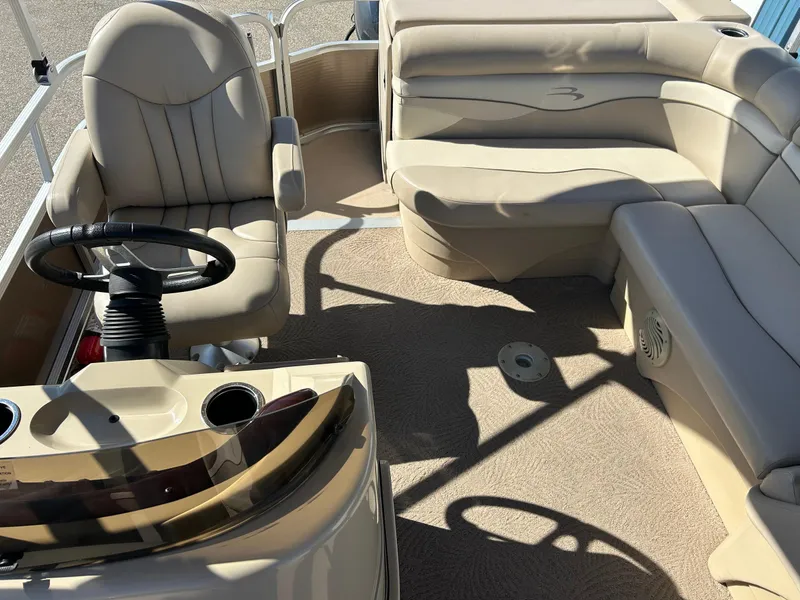 Slide: The Image of 2012 Bennington 20SLi pontoon boat interior with beige seating and steering console. - 23