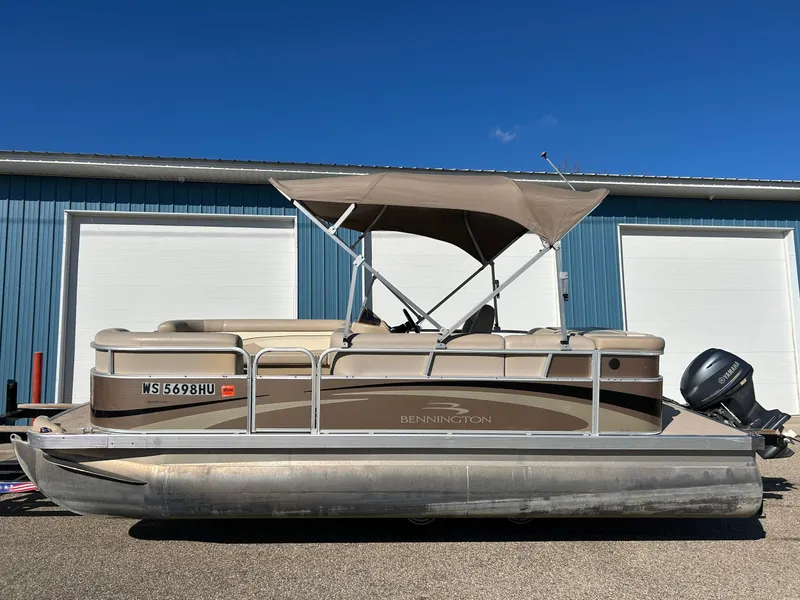 Slide: The Image of 2012 Bennington 20SLi pontoon boat with canopy, parked near blue garage doors. - 25