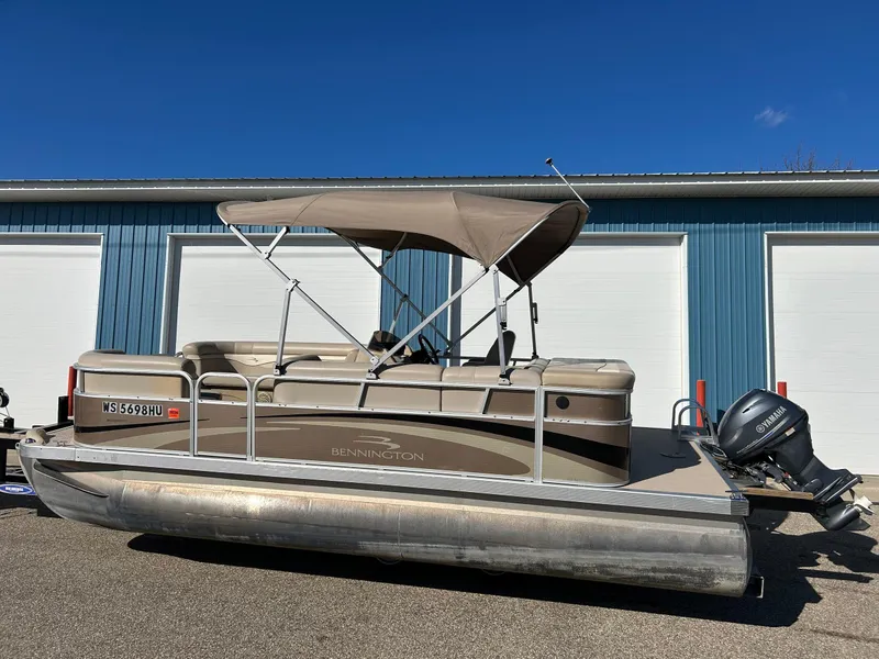 Slide: The Image of 2012 Bennington 20SLi pontoon boat with canopy, parked near blue garage doors. - 26