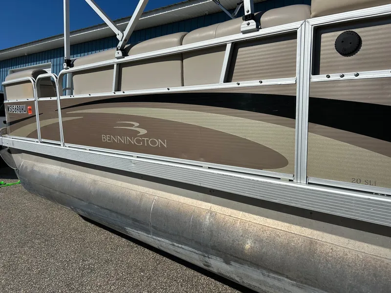 Slide: The Image of 2012 Bennington 20SLi pontoon boat, beige and brown design, docked outdoors. - 27