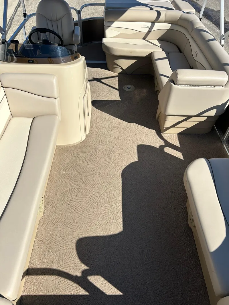 Slide: The Image of 2012 Bennington 20SLi pontoon boat interior with beige seating and carpet. - 28