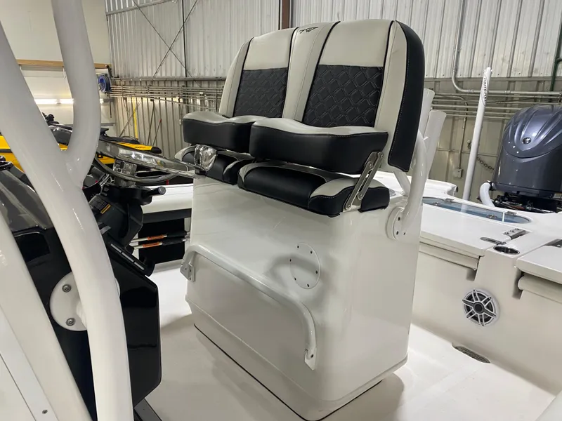 Slide: The Image of 2022 Tidewater 2500 Carolina Bay boat interior with dual black and white seats. - 13