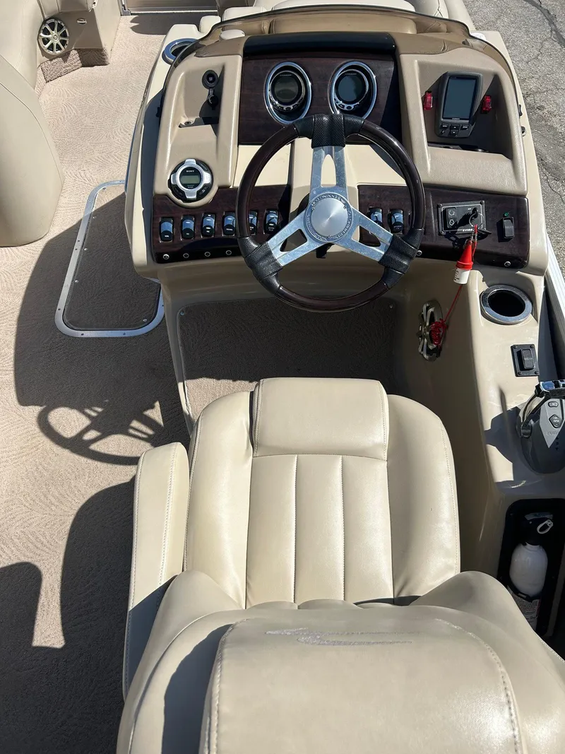 Slide: The Image of Steering console of a 2012 Bennington 2250RCL boat with beige seating and controls. - 10