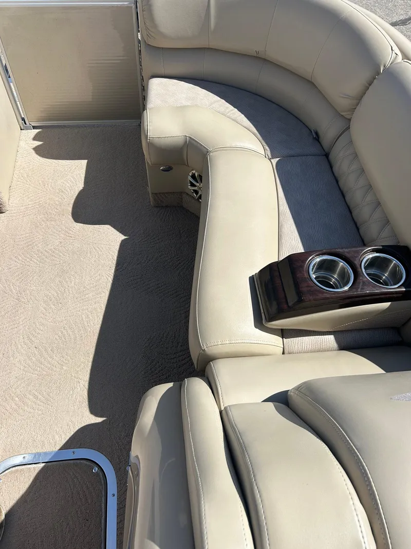 Slide: The Image of 2012 Bennington 2250RCL boat interior with beige seating and cup holders. - 12