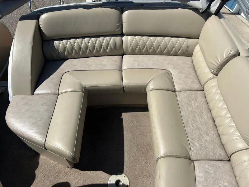 Slide: The Image of 2012 Bennington 2250RCL boat interior with beige cushioned seating and carpeted floor. - 15