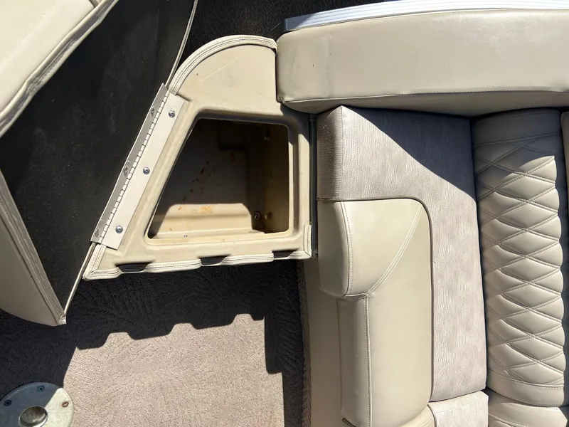 Slide: The Image of 2012 Bennington 2250RCL boat interior with open storage compartment and cushioned seating. - 24
