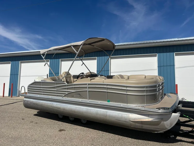 Slide: The Image of 2012 Bennington 2250RCL pontoon boat parked outdoors under a clear blue sky. - 4