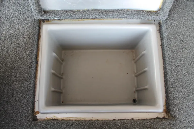 Slide: The Image of Empty storage compartment in 2013 Ranger RT188 boat, featuring gray carpet lining. - 15