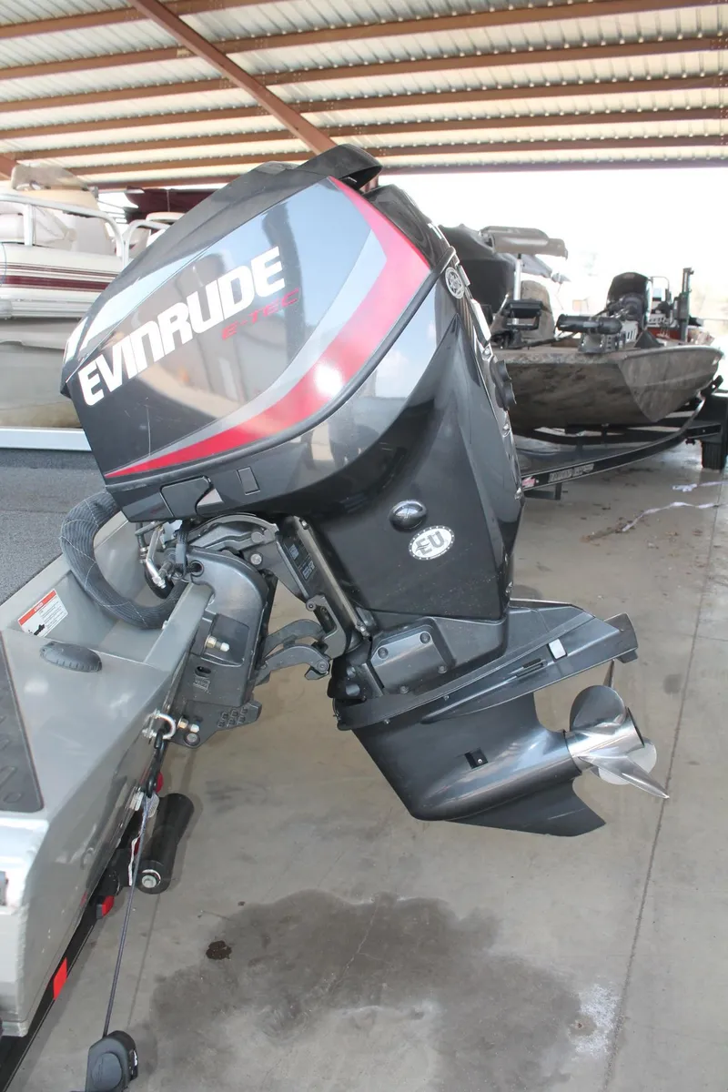Slide: The Image of 2013 Ranger RT188 boat with Evinrude outboard motor in a covered storage area. - 17