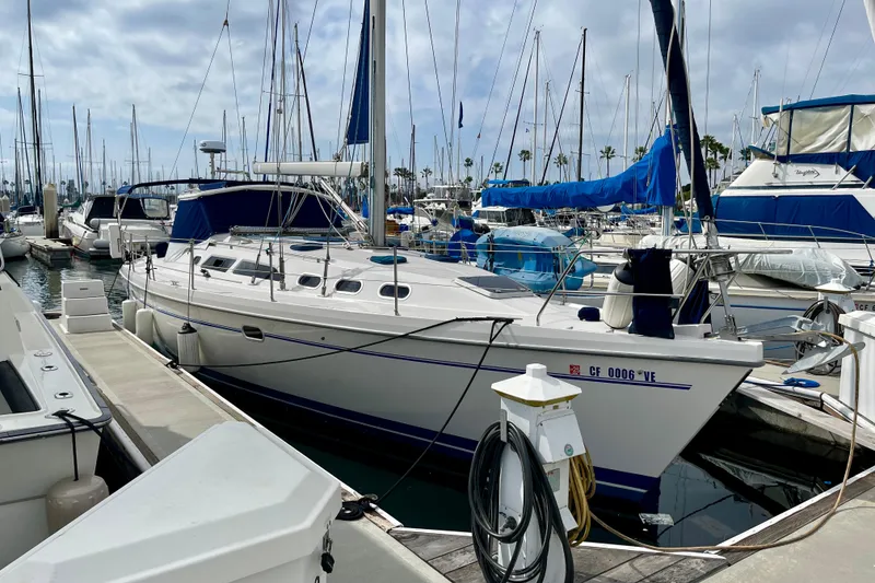 Slide: The Image of 2001 Catalina 380 sailboat docked in marina, surrounded by other boats. - 0