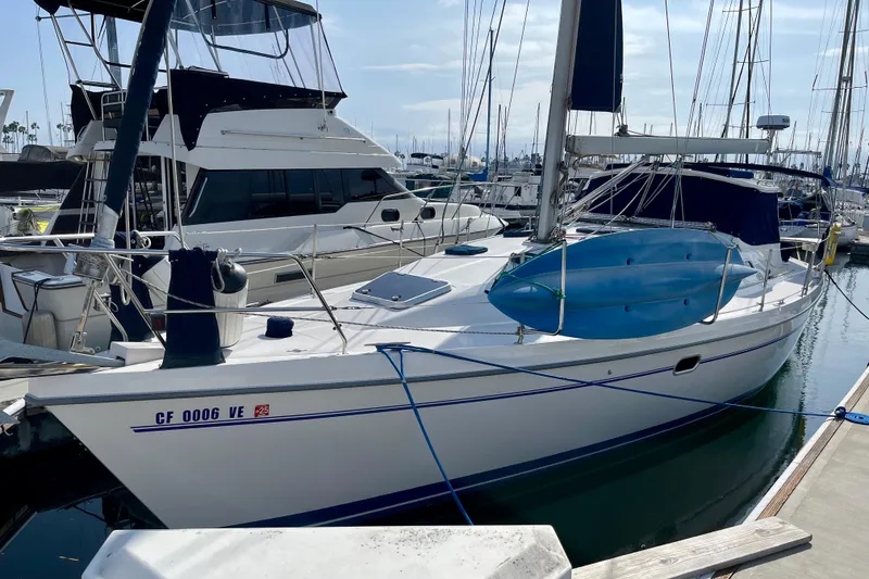 Slide: The Image of 2001 Catalina 380 sailboat docked at marina, featuring sleek design and blue kayak on deck. - 1