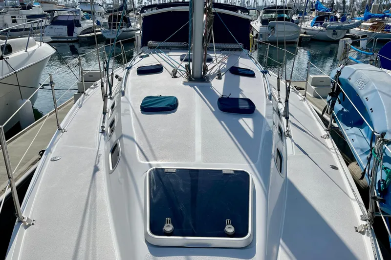 Slide: The Image of 2001 Catalina 380 sailboat deck view in marina, showcasing hatches and rigging. - 11