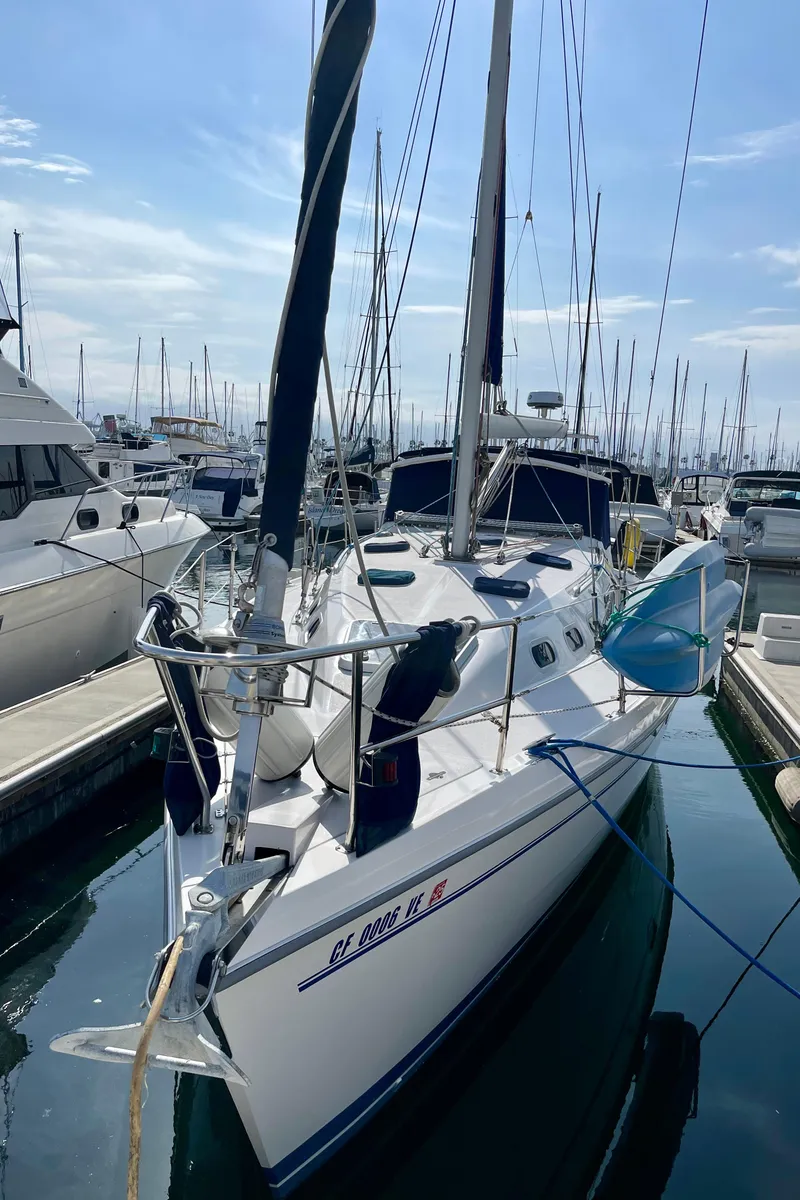 Slide: The Image of 2001 Catalina 380 sailboat docked in marina, clear sky, calm water. - 2