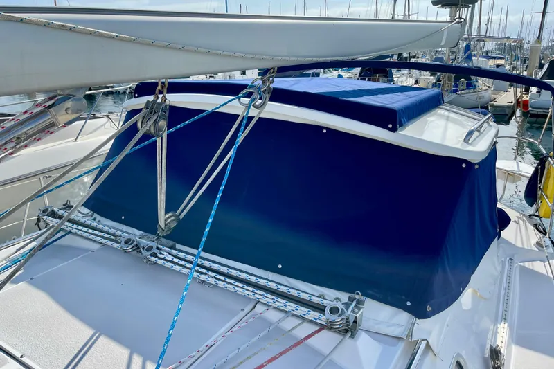 Slide: The Image of Catalina 380 sailboat, 2001 model, featuring blue canvas cover and rigging in a marina setting. - 20
