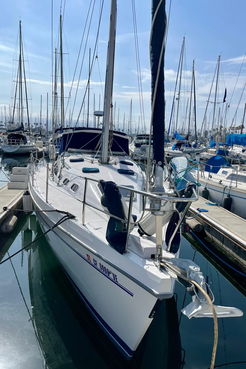Slide: The Image of 2001 Catalina 380 sailboat docked in a marina under a clear blue sky. - 3