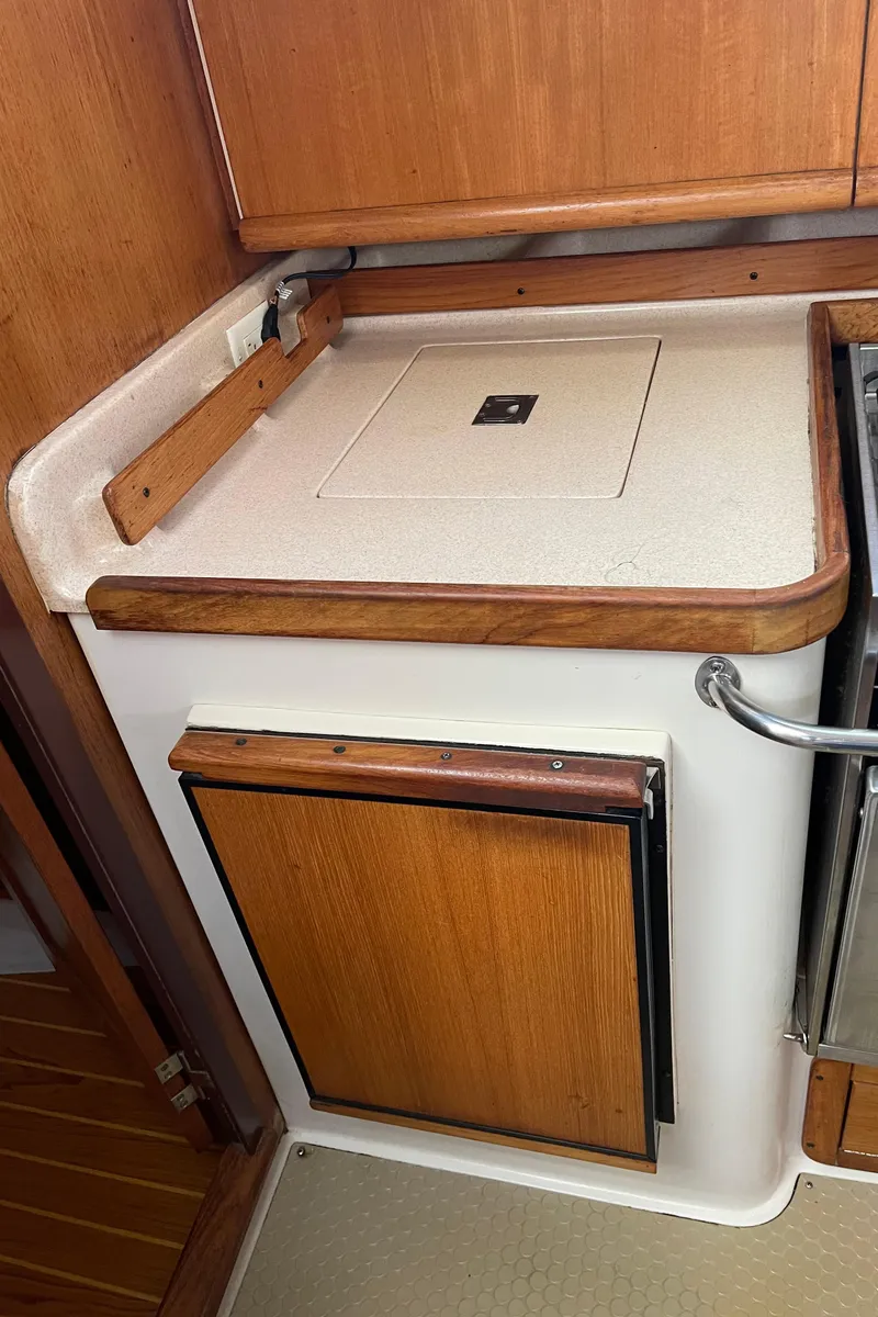 Slide: The Image of 2001 Catalina 380 yacht interior with wooden cabinetry and compact kitchen area. - 30