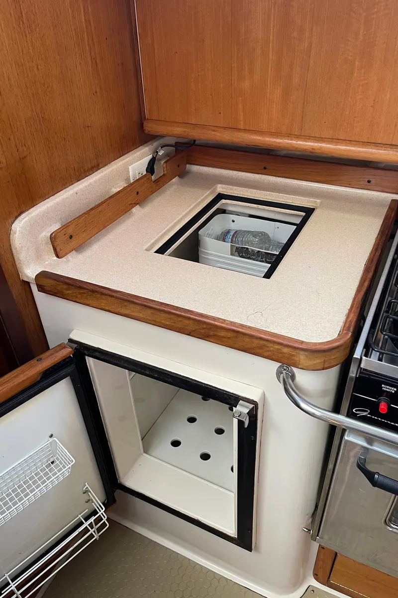 Slide: The Image of Catalina 380 yacht kitchen with open fridge, wooden trim, and countertop, 2001 model. - 31