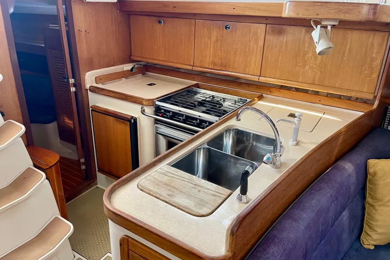 Slide: The Image of Interior of 2001 Catalina 380 yacht kitchen with stove, sink, and wooden cabinetry. - 33