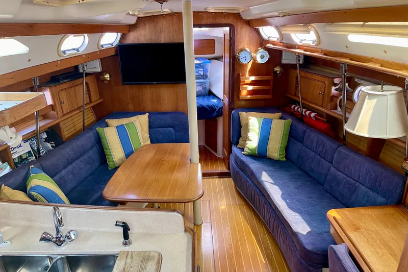 Slide: The Image of Interior of a 2001 Catalina 380 sailboat with cozy seating and wooden finishes. - 34