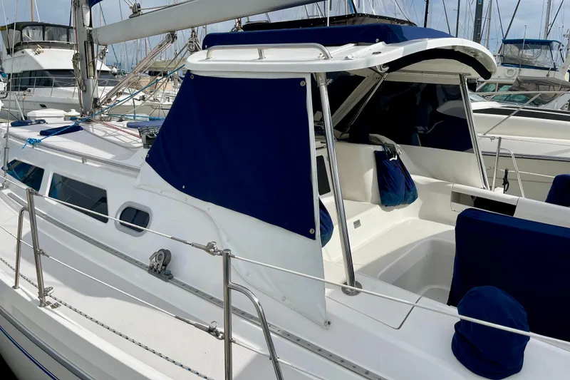 Slide: The Image of 2001 Catalina 380 sailboat with blue canvas cover in marina setting. - 4