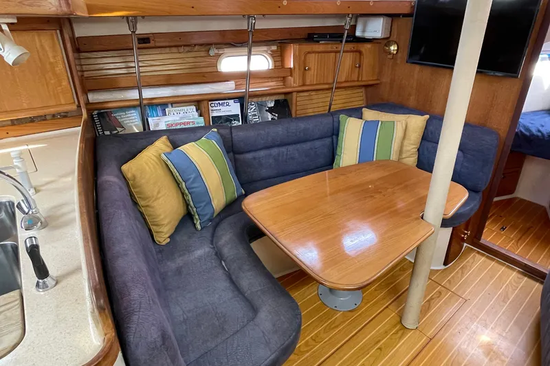 Slide: The Image of Interior of a 2001 Catalina 380 sailboat with cozy seating and wooden table. - 43