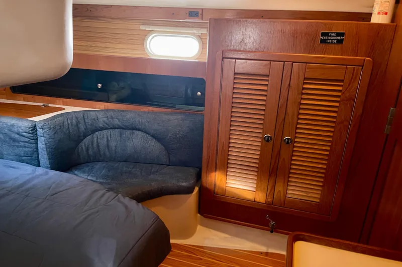 Slide: The Image of Interior of 2001 Catalina 380 sailboat with wooden cabinets and blue seating. - 44