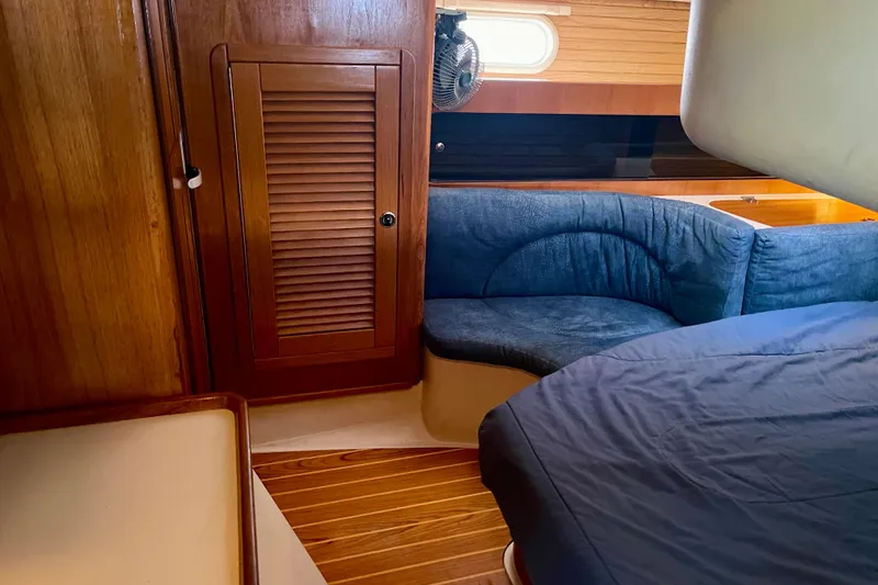 Slide: The Image of Cozy interior of 2001 Catalina 380 sailboat with wooden cabinetry and blue seating. - 46