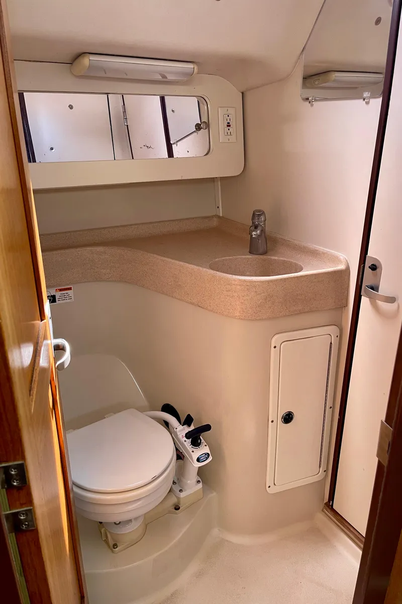 Slide: The Image of 2001 Catalina 380 yacht bathroom with sink, toilet, and storage cabinets. - 47