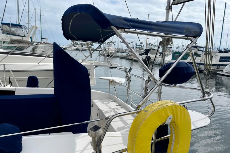 Slide: The Image of 2001 Catalina 380 sailboat with blue canopy and yellow life ring in marina. - 6