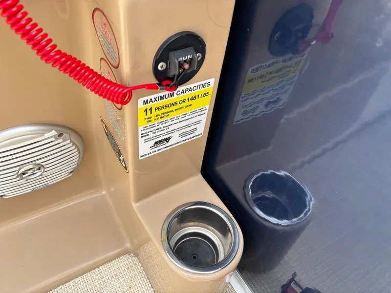 Slide: The Image of 2014 Harris Cruiser 220 boat capacity label and cup holder detail. - 12