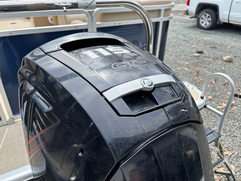 Slide: The Image of 2014 Harris Cruiser 220 boat with Mercury outboard motor, parked on gravel. - 15