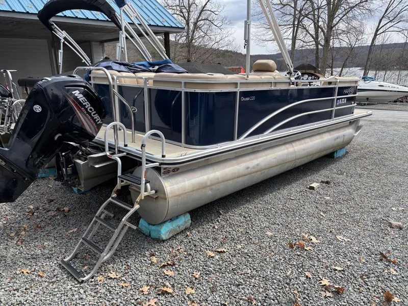 Slide: The Image of 2014 Harris Cruiser 220 pontoon boat with Mercury engine on gravel lot. - 16