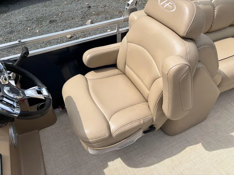 Slide: The Image of 2014 Harris Cruiser 220 boat seat with beige upholstery and steering wheel. - 18