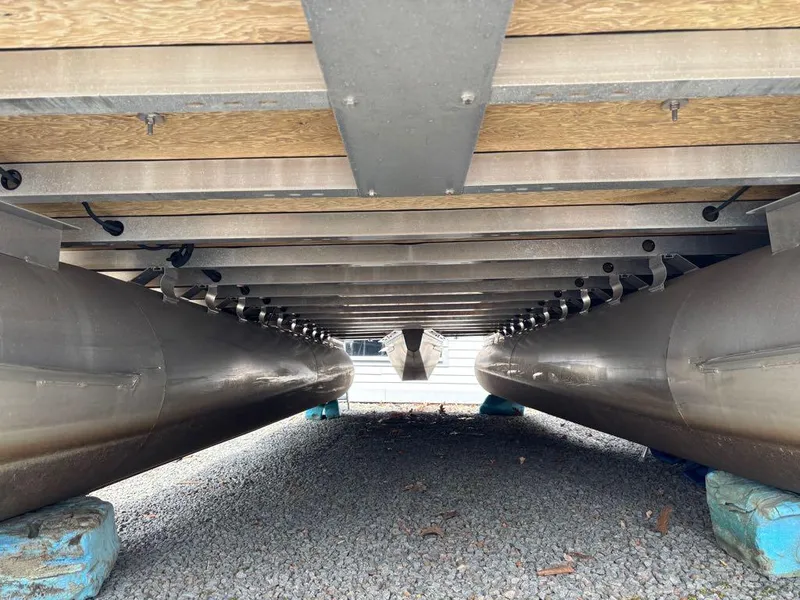 Slide: The Image of Underneath view of a 2014 Harris Cruiser 220 pontoon boat on gravel. - 7