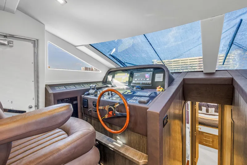 Slide: The Image of 2009 Uniesse 65 MY yacht helm with leather seating and modern navigation controls. - 16