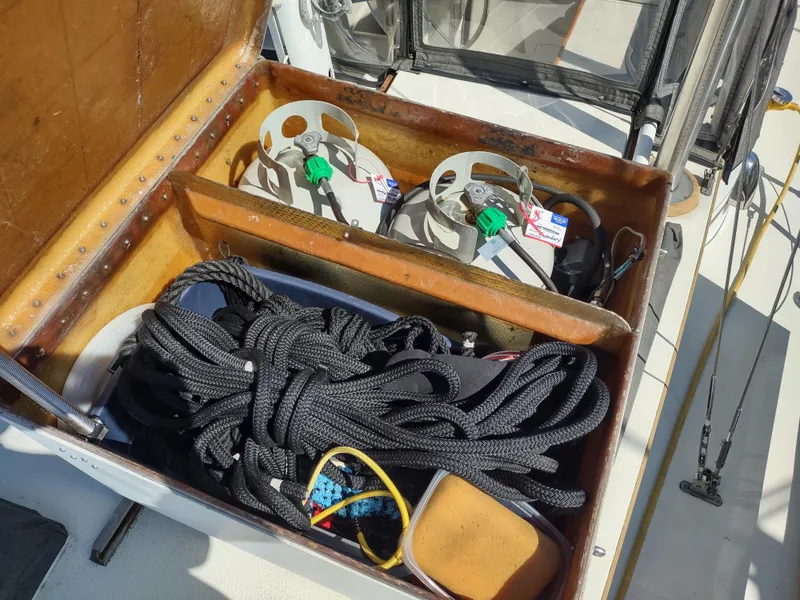 Slide: The Image of Storage compartment on 1979 Islander Freeport 41 sailboat with ropes and gas cylinders. - 14