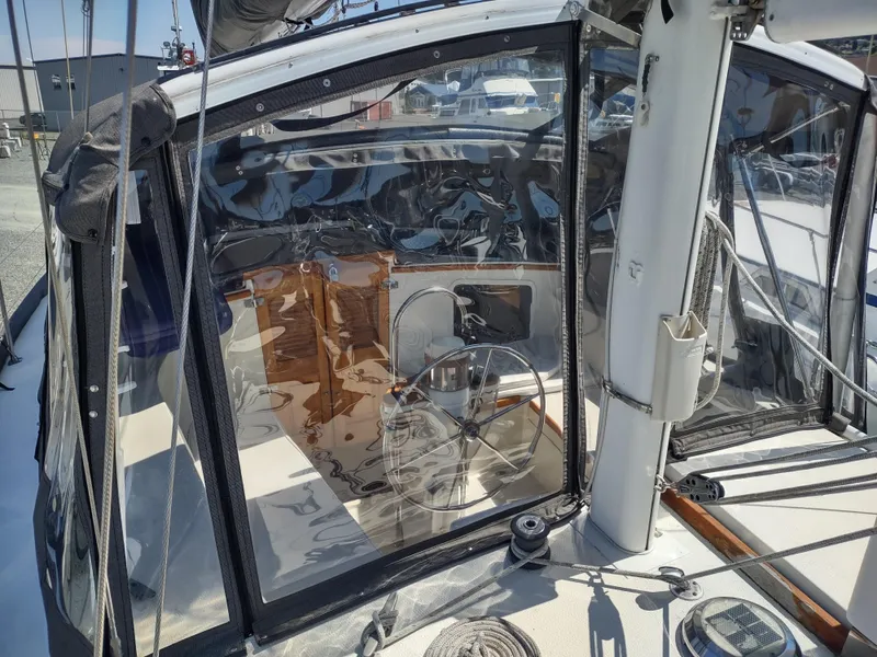 Slide: The Image of 1979 Islander Freeport 41 sailboat cockpit with clear enclosure and visible steering wheel. - 17