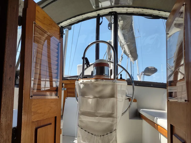 Slide: The Image of Interior view of 1979 Islander Freeport 41 sailboat cockpit with wooden doors and steering wheel. - 25