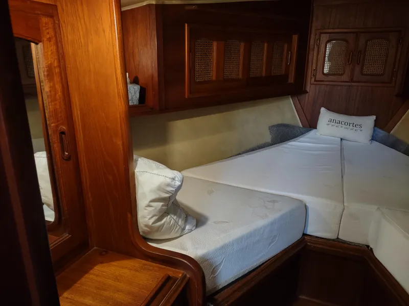 Slide: The Image of 1979 Islander Freeport 41 yacht cabin with wooden interior and cozy bedding. - 41