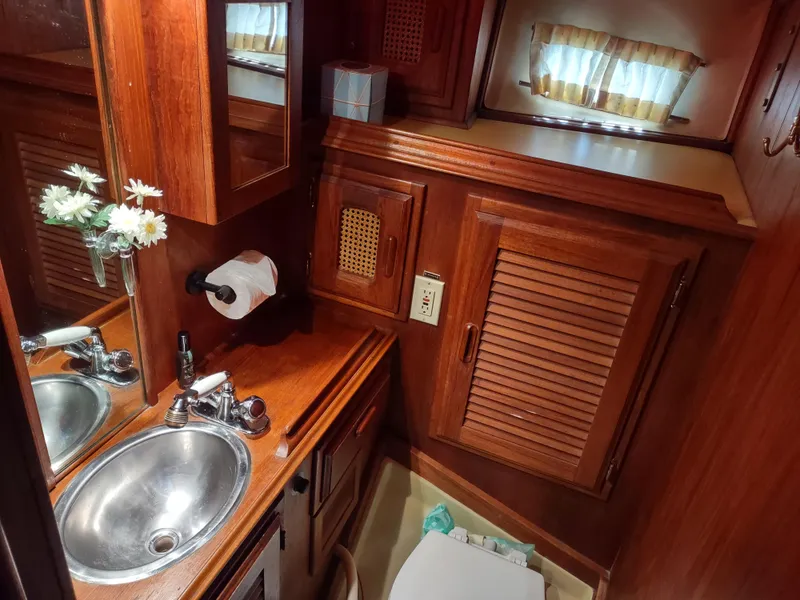 Slide: The Image of 1979 Islander Freeport 41 yacht bathroom with wooden cabinetry and stainless steel sink. - 43
