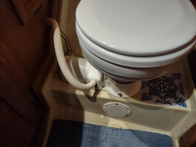 Slide: The Image of 1979 Islander Freeport 41 boat bathroom with marine toilet and blue mat. - 44