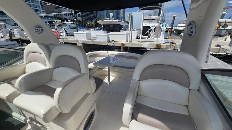 Slide: The Image of 2003 Sea Ray 340 Sundancer interior with plush seating at a marina. - 14