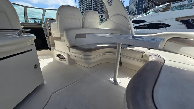 Slide: The Image of 2003 Sea Ray 340 Sundancer interior with seating and table, docked near other yachts. - 15